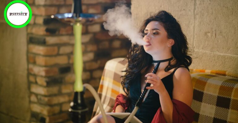 a girl is inhaling vaping sitting on a cough in black dress