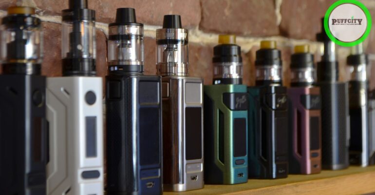 Different types and colors of vapes are lined up along the background of the wall