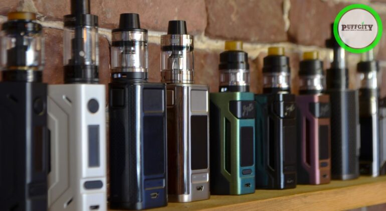 Different types and colors of vapes are lined up along the background of the wall