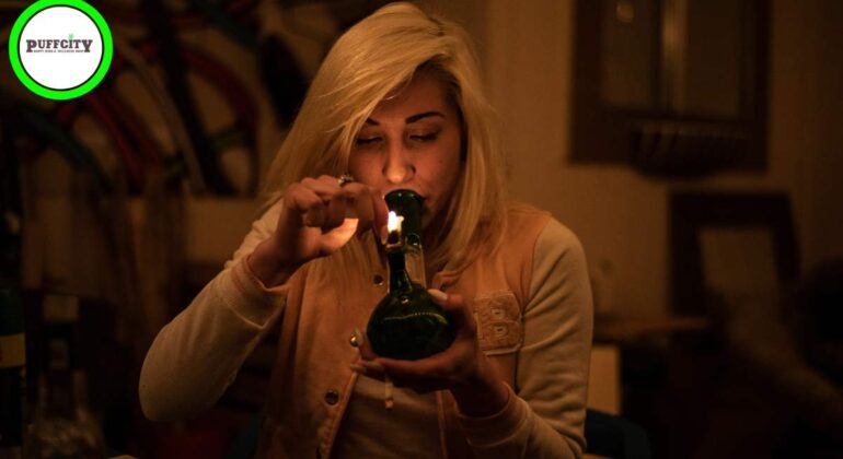 A girl starts a black bong in a room in midlights.