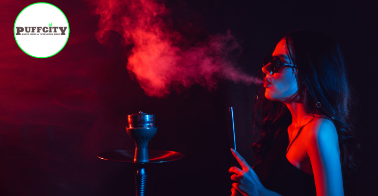 a elegant girl is puffing from glass water pipe in dark room or in black dress with blac glasses.
